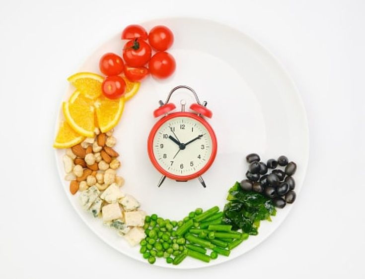 Clock and healthy vegan snacks symbolizing importance of timely meals for diabetes blood sugar control