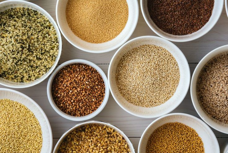 Top view of different types of Indian millets like Kodo (Arikelu), Barnyard (Udalu), Little millet (Samalu), Jowar (Jonna), and Bajra (Sajjalu) arranged in bowls—showing variety for weekly rotation in a diabetic diet.